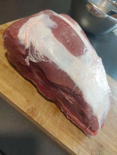 raw meat sitting on top of a wooden cutting board