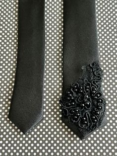 two ties with black lace on them sitting on a polka dot tablecloth covered surface