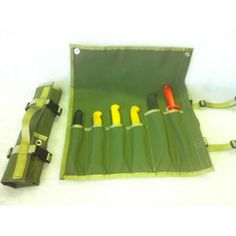 an open green case with five different colored pens in it and two carrying cases on the side