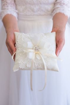 a person holding a wedding ring pillow in their hands