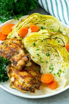 a white plate topped with chicken, cabbage and carrots