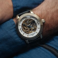 This three hand, automatic skeleton is a delightful aesthetic indulgence, with exposed mechanics and delicate yet lavish gems. Utter precision and care form the backbone of this timepiece. SPECIFICATIONS MOVEMENT: Automatic Skeleton 3 Hands with Open Heart CASE MATERIAL: Stainless Steel CASE DIAMETER (mm): 48 CASE THICKNESS (mm): 16 CASE COLOUR: Ionic Plating - Gold BAND: 22mm Black Genuine Leather Strap WATER RESISTANCE: 5 ATM WATCH WEIGHT (g): 100 Steampunk Silver Watch With Skeleton Dial, Steampunk Automatic Watch For Formal Occasions, Gold Steampunk Watch With Skeleton Dial, Elegant Silver Watch With Skeleton Dial, Steampunk Watch With Skeleton Dial, Timeless Watch Accessories With Rotating Bezel, Elegant Automatic Watch Accessories For Gift, Steampunk Watches With Round Dial For Formal Occasions, Steampunk Watches For Formal Occasions