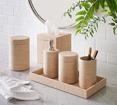 the bathroom accessories are arranged on the marble counter top, with a round mirror in the background