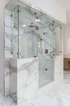 a bathroom with marble walls and flooring next to a walk - in shower stall