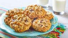 cookies and milk on a blue plate with colorful napkins next to glass of milk