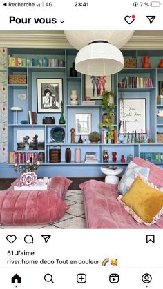 the room is decorated in pink and blue with lots of bookshelves on it