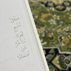 an open book with arabic writing on the cover and carpet in the background, close up