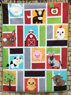 a quilt hanging on the side of a brick wall with farm animals and barnyards