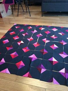 a black and purple rug with pink triangles on it