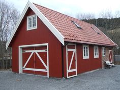 a red and white garage with two doors on the front, one door open to let in light