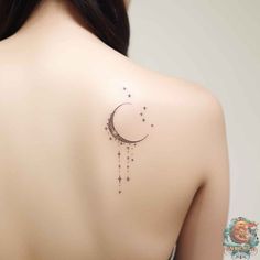 the back of a woman's shoulder with a crescent and stars tattoo on it