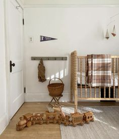 a baby's room with toys on the floor and a crib in the corner