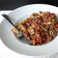 a white plate topped with pasta and meat