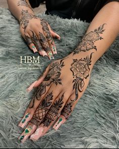 a woman's hand with henna tattoos on it and her hands in the middle