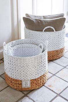 two baskets with handles are sitting on the floor