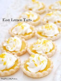 lemon tarts with white icing and yellow sprinkles on a table