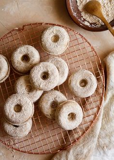 powdered doughnuts on a wire rack with a wooden spoon