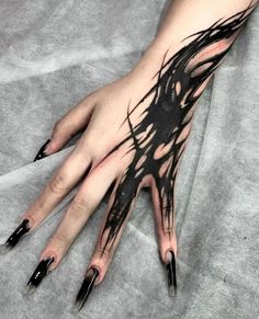 a woman's hand with black nail polishes on it