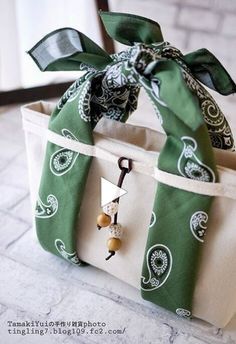 a green and white bag with a bow on it