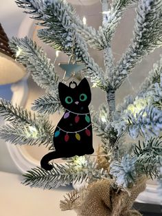 a black cat ornament hanging from a christmas tree