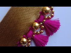 a gold and pink necklace with tassels on it