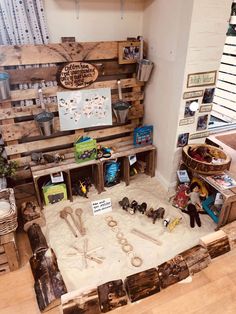 a room filled with lots of wooden pallets and toy animals on top of it