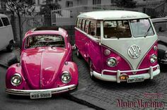 two purple and white vw buses parked next to each other