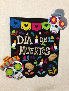 a sign that says dia de muertos with sugar skulls and decorations on it