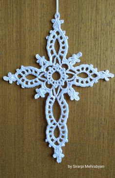 a crocheted snowflake ornament hanging on a wooden surface