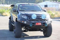 the front end of a black four - door pick up truck parked in a parking lot