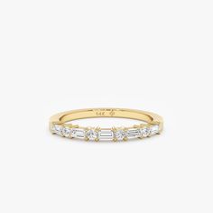 a yellow gold band with five baguettes on the side, set in white diamonds