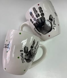 two coffee mugs with hand prints on them