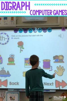 a young boy standing in front of a white board with pictures on it and pointing to the screen