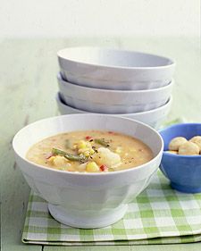 three bowls of soup are sitting on a green and white checkered placemat, one bowl has dumplings in it