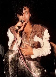 michael jackson performing on stage with microphone in his hand and wearing an elaborately designed outfit