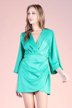 An absolute lux dress! Pair with gold jewelry, a pair of heels and you will be sure to stand out. This piece features mid length kimono - style sleeves and a mini overlay skirt. V neckline Elastic-lined waist Mini length Wrap skirt-area Pullover Semi-textured satin finish 100% Polyester Made in USA SKU #: D-8042 Green Mini V-neck Evening Dress, Chic V-neck Mini Dress With Draped Sleeves, Spring Formal Faux Wrap Dress, Formal Faux Wrap Dress For Spring, Satin V-neck Wrap Dress For Formal Occasions, Formal Satin V-neck Wrap Dress, Chic Satin Mini Dress With Draped Sleeves, Chic Satin Dress With Draped Sleeves, Cocktail Faux Wrap Dress