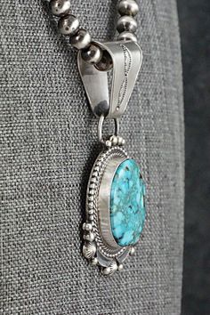 This stunning natural Kingman turquoise and sterling silver necklace was made by Navajo silversmith Tom Lewis. The back is signed Tom Lewis and stamped sterling.Necklace: 18"Pendant Length: 2 3/8"Pendant Width: 1 1/8"Bead Size: 1/4" (6mm)Free shipping on all orders! We ship with USPS and always include tracking. All orders ship within a day of payment.Returns are accepted up to 30 days after you receive your order. Just send us a message. Our shop offers cash back or store credit. The item must Southwestern Engraved Turquoise Necklace In Sterling Silver, Western Sterling Silver Turquoise Pendant Necklace, Western-style Sterling Silver Turquoise Pendant Necklace, Western Style Turquoise Pendant Necklace In Sterling Silver, Southwestern Turquoise Necklace With Large Round Pendant, Untreated Southwestern Turquoise Pendant Necklace, Southwestern Sterling Silver Turquoise Necklace With Large Pendant, Southwestern Turquoise Pendant Necklace Stamped 925, Kingman Turquoise