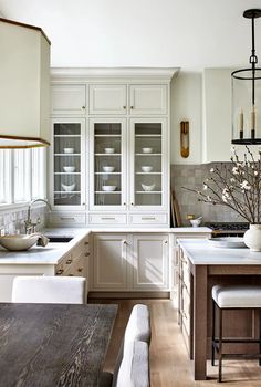 a kitchen with white cabinets and wooden floors