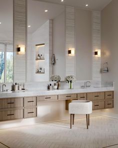 a large bathroom with two sinks and mirrors on the wall, along with stools