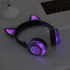 a pair of headphones sitting on top of a desk next to a laptop computer