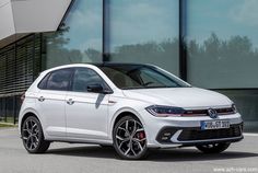 a white volkswagen car parked in front of a building