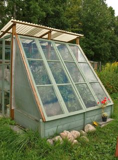 a green house with lots of windows in the grass