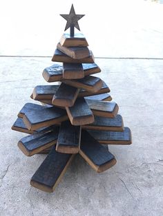 a wooden christmas tree made out of books on the ground with a star on top