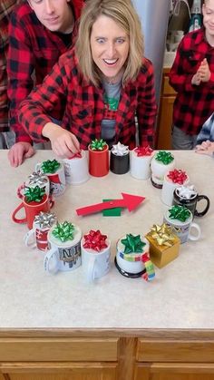 a man and woman sitting at a kitchen table with christmas gifts in front of them