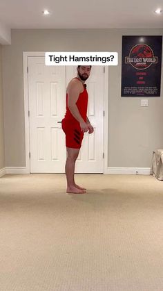 a man in a red swimsuit is standing in the middle of an empty room