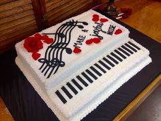 a sheet cake decorated with music notes and red roses