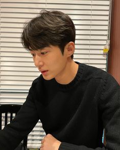 a young man sitting at a table using a laptop computer