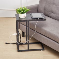 a small table with a tablet on it next to a couch