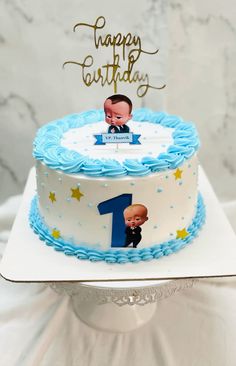 a blue and white birthday cake with an image of a baby on it