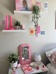 a white desk topped with a mirror next to a pink shelf filled with potted plants